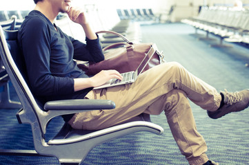 空港の待合室でノートパソコンを使っている男性
