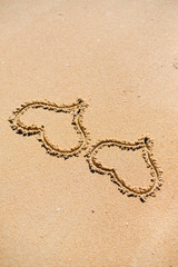 Two hearts drawn on the sand of a beach