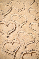 Love hearts drawn on texture of sand background