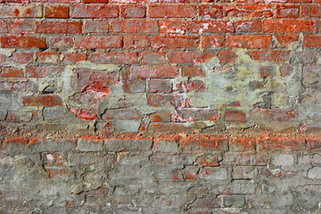 Red old dirty brick wall background. Old damaged brick wall with plaster