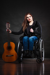 Fototapeta na wymiar Woman invalid girl on wheelchair with guitar