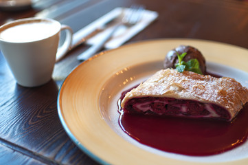 Plate of cherry strudel and cup of coffee