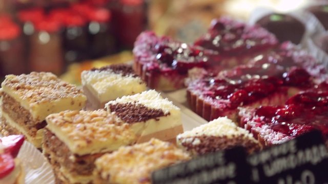 Show window in a grocery shop or a bakery. Tasty and delicious  potato cakes, tarts with strawbery, cream,  jelly finishing, red currants and icing shugar.
