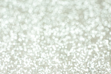 Silver festive glitter bokeh background with defocused