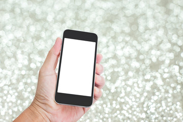 Hand holding mobile phone with festive silver glitter background