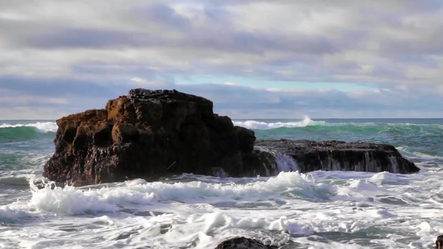 Waves crashing against some rocks at a beach, shot with a Canon 6D