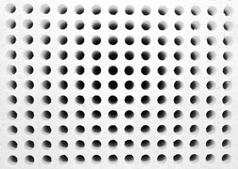 Styrofoam square with rows of small holes in black and white