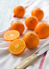 Wet fresh tangerine with knife on the towel in the sunny day