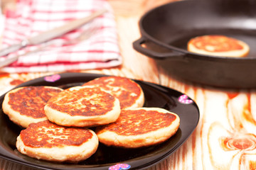 Beautiful golden cheese pancakes fried in a pan. Syrniki.