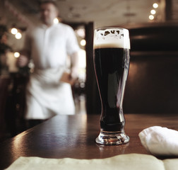 glass of dark beer in a restaurant interior