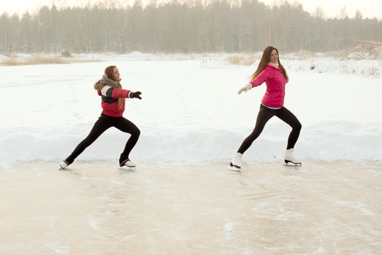 Coach of figure skating with apprentice practise at the frozen lake in the winter