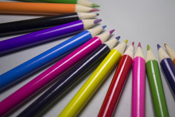 Variety of pencils aimed to the center of the paper