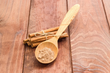 Cinnamon sticks and cinnamon powder in a wooden spoon