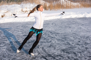 young Figure skating woman at the frozen lake in the winter