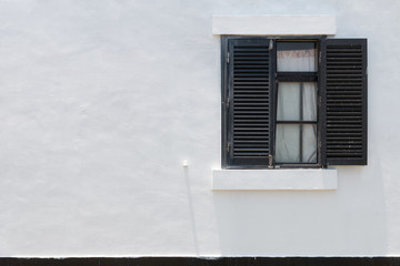 Window with brown blinds on white wall