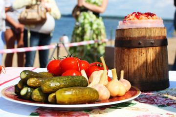 Traditional Russian pickled tomatoes, cucumbers and garlic, sauerkraut with cranberries on the festive table