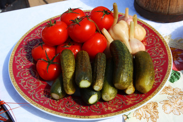 Traditional Russian pickled tomatoes, cucumbers and garlic on the festive table