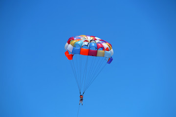 Parasailing girl against a blue sky