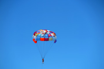 Parasailing girl against a blue sky
