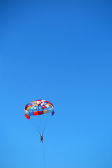 Parasailing girl against a blue sky