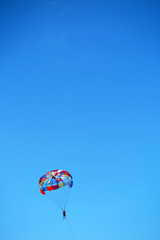 Parasailing girl against a blue sky