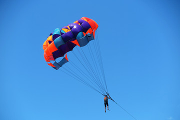 Parasailing girl against a blue sky