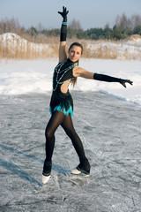 young Figure skating woman at the frozen lake in the winter