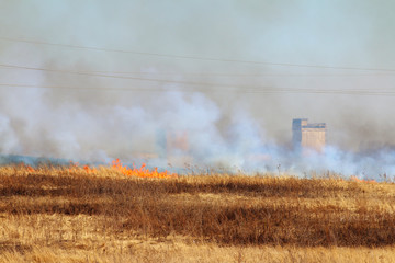 Fototapeta premium Line of the fire coming to industrial city district - burning me