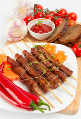Shish kebab with herbs on a white plate