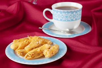 Puff pastry with sesame seeds on a blue cup.