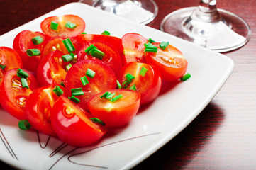 Cherry tomatoes decorated with green onions.