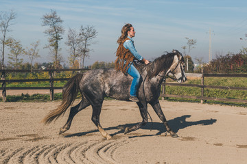 Naklejka premium Pretty girl riding her grey horse
