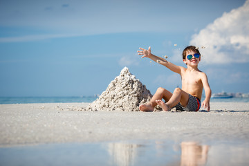 Cute little son building sand castle at beach on Florida