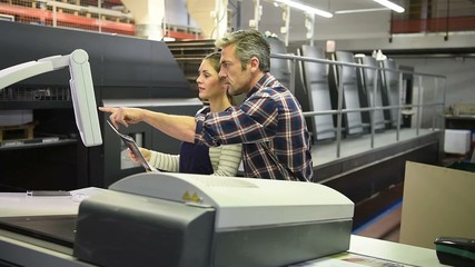 Man working with apprentice in printing house