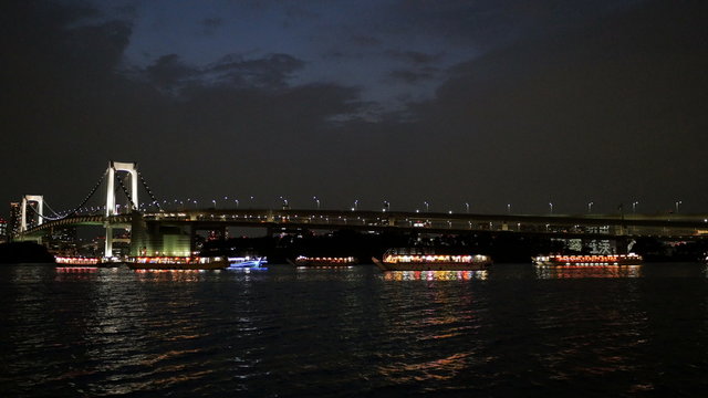 Colorful party boats gather off the shore at Daiba.
