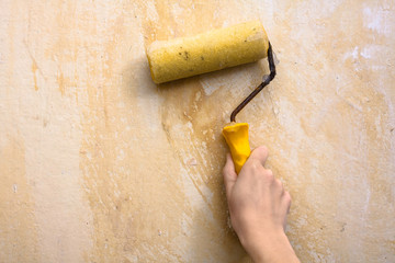 hand smearing wall with glue