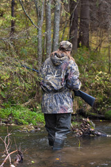Fototapeta na wymiar woman crossing small river on the hunting