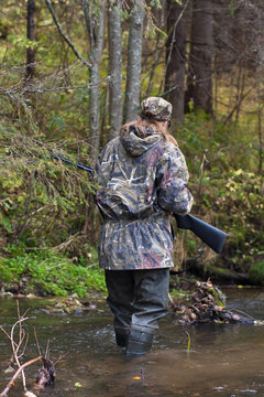 woman crossing small river on the hunting