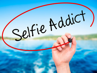 Man Hand writing Selfie Addict with black marker on visual scree