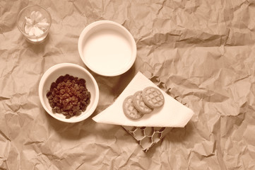 Obraz na płótnie Canvas colazione vintage, latte, biscotti, uvetta, monocromatica seppia, vista dall'alto 