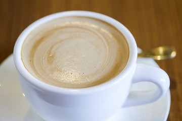 Flat white hot coffee on wood table