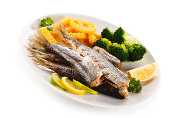 Fried herrings, chips and vegetables