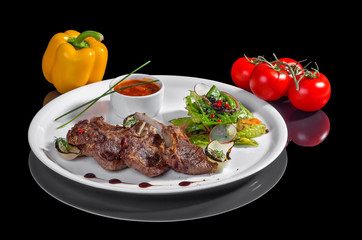 Жареное мясо с овощами на черном фоне