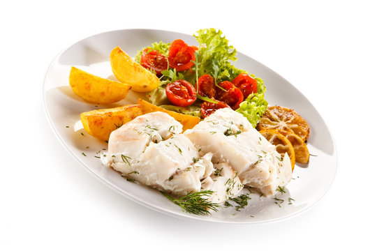 Fish dish -  boiled fish fillet, baked potatoes and vegetables 