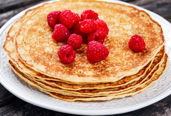 Stack of Fresh golden pancakes with raspberries