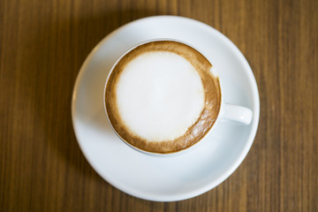 Hot Cappuccino with white cup on wood table coffee house