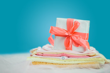 The baby clothes with a  white gift box