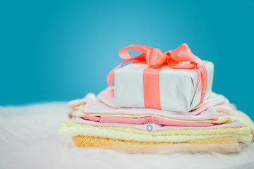 The baby clothes with a  white gift box