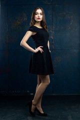 Fototapeta na wymiar Beautiflul young woman wearing black dress on black background