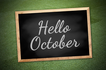 Hello October on chalk board and green field background and text